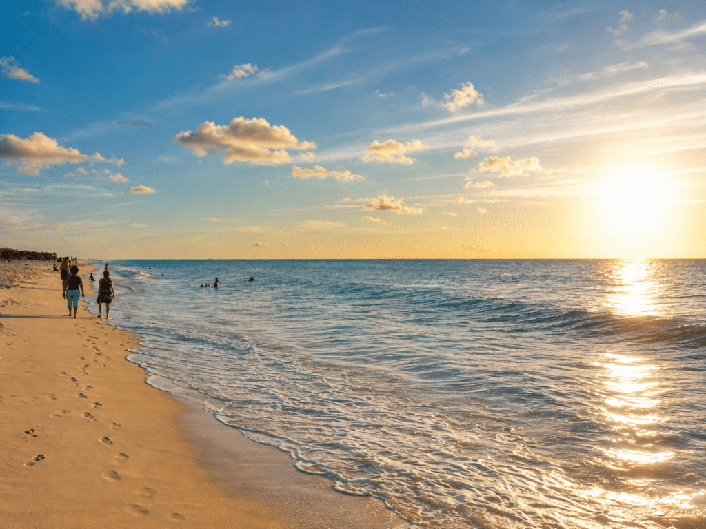 Breed zandstrand op Eagle Beach Aruba met zee tijdens zonsondergang