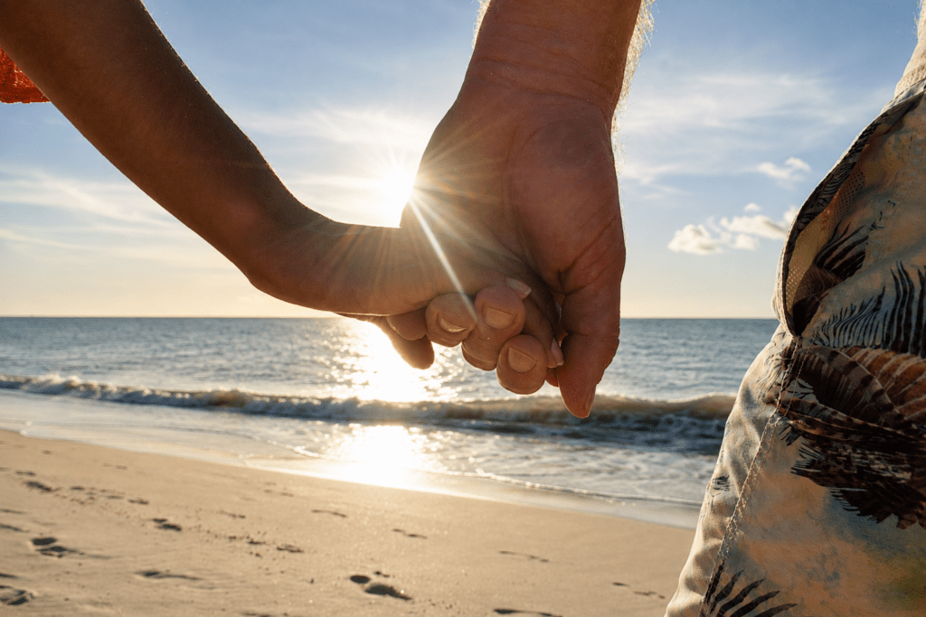 Hand in hand tijdens een strandwandeling op Eagle Beach Aruba