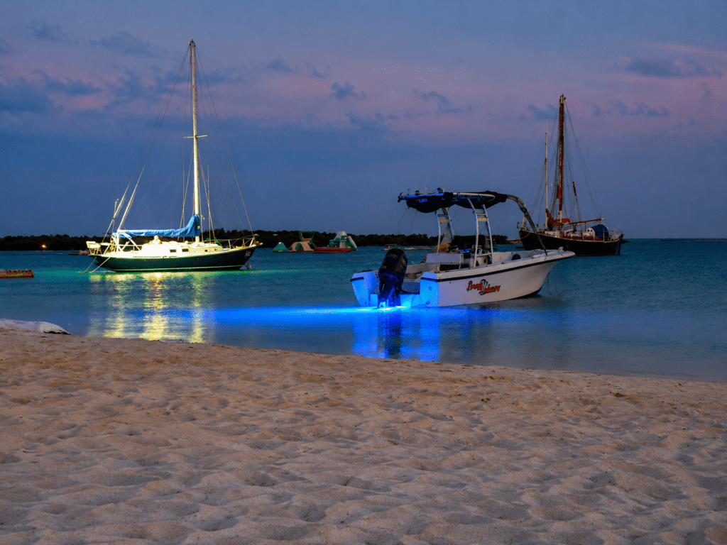 Boten voor de kust van Surfside Beach Aruba in de avond