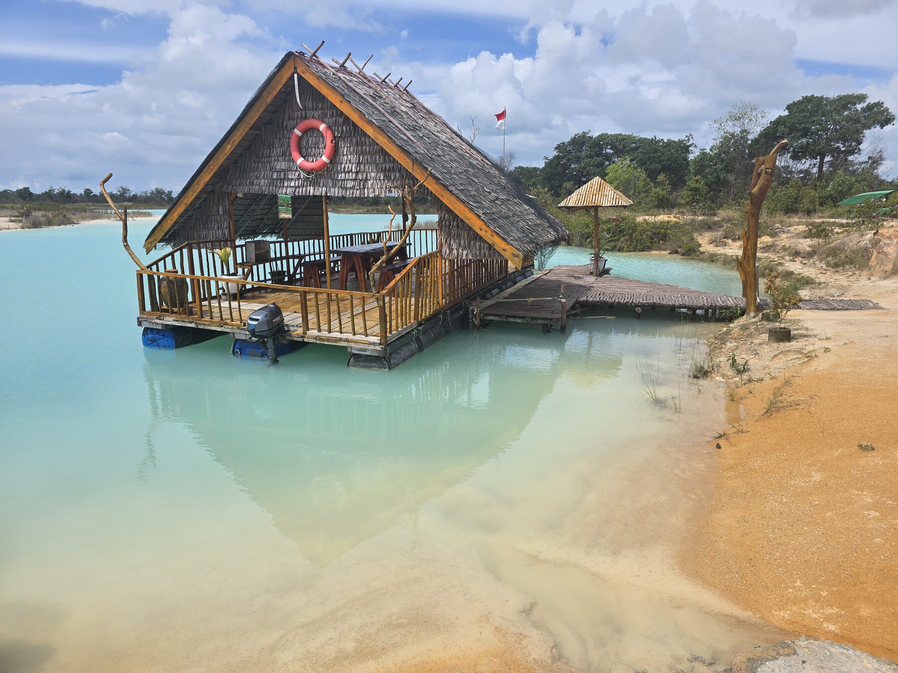 Houten huisje aan het blauwgroene water van Blue Lake op Bintan