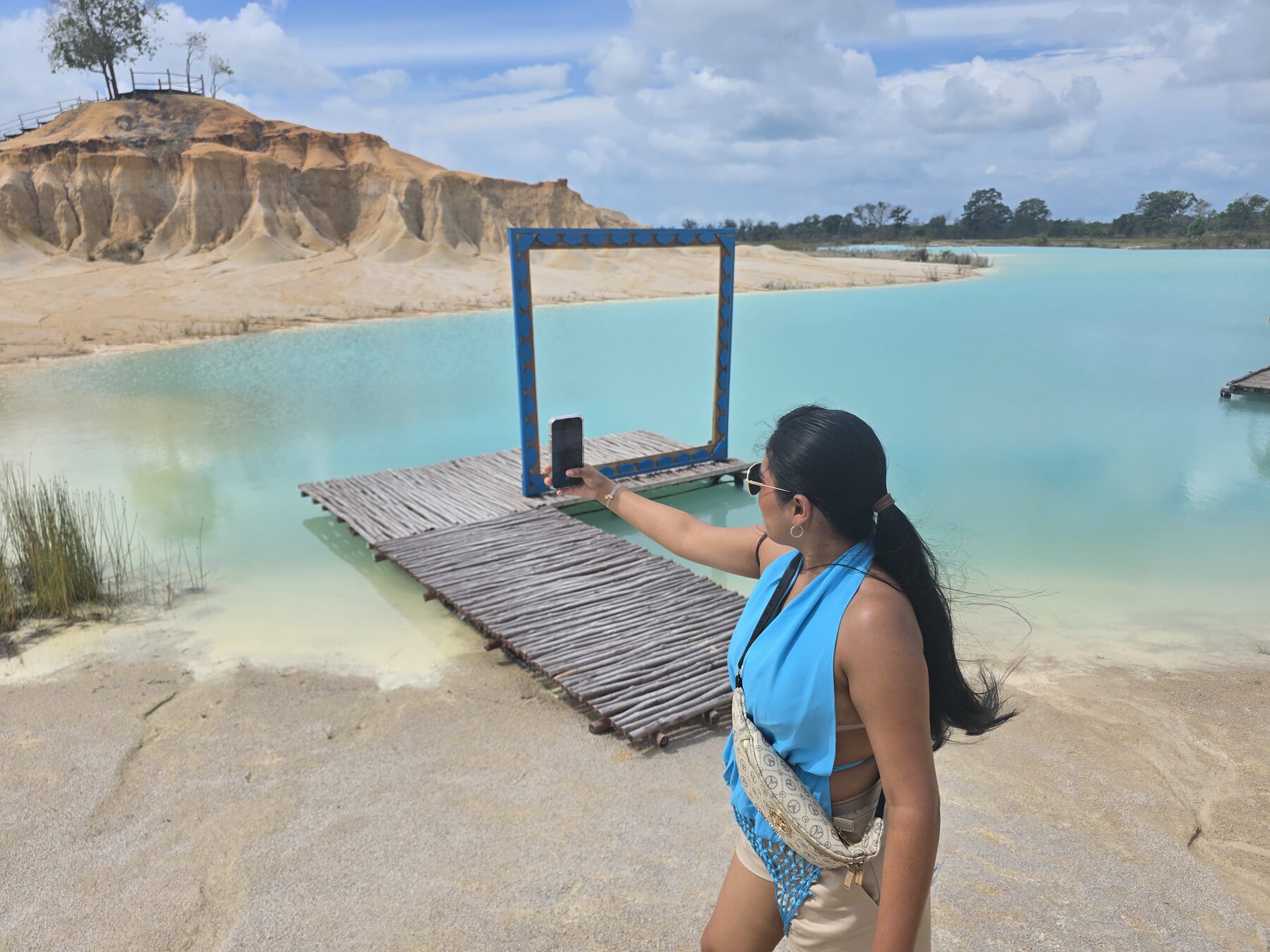 Reiziger bij een houten fotoplatform aan Blue Lake op Bintan