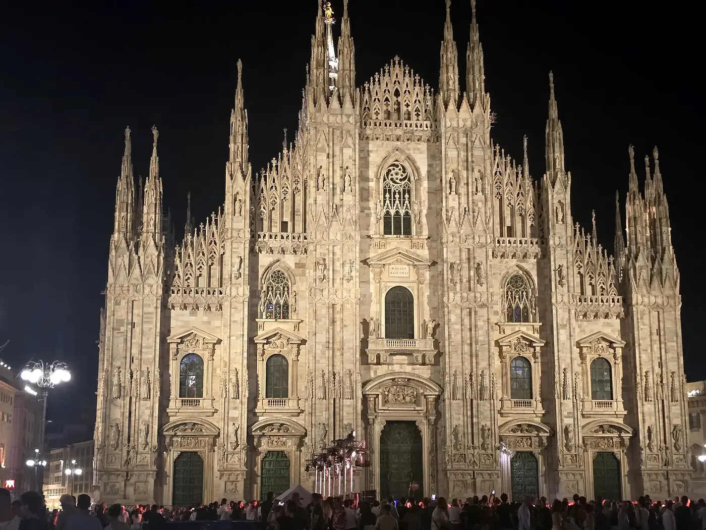 Verlichte voorgevel van de Duomo di Milano bij nacht