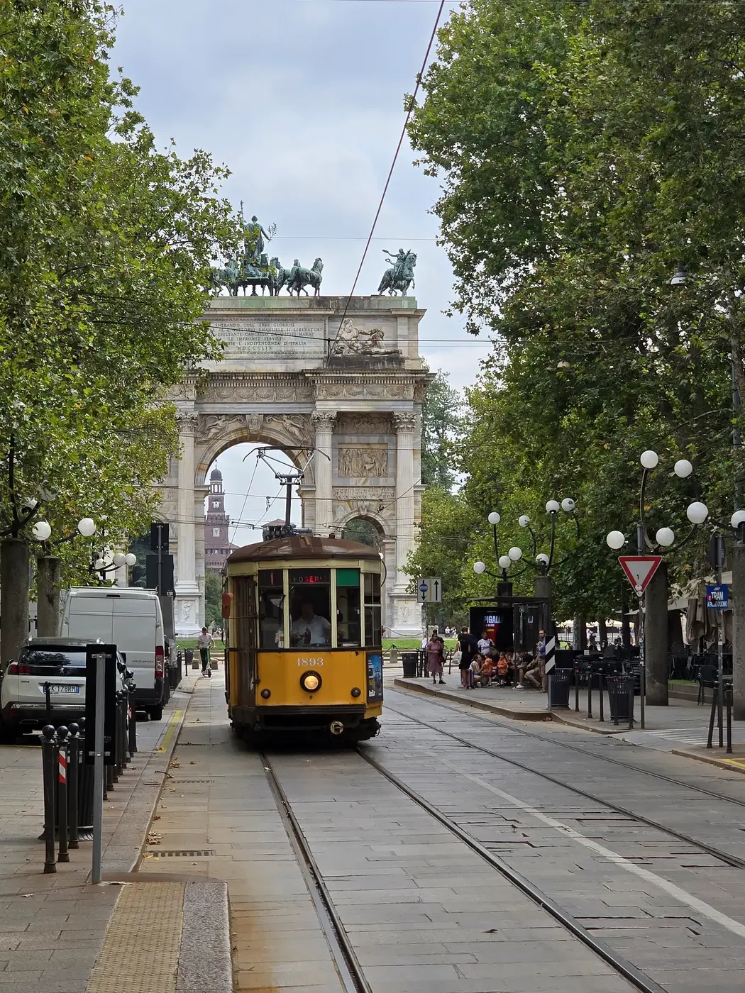 Historische gele tram voor Arco della Pace in Milaan