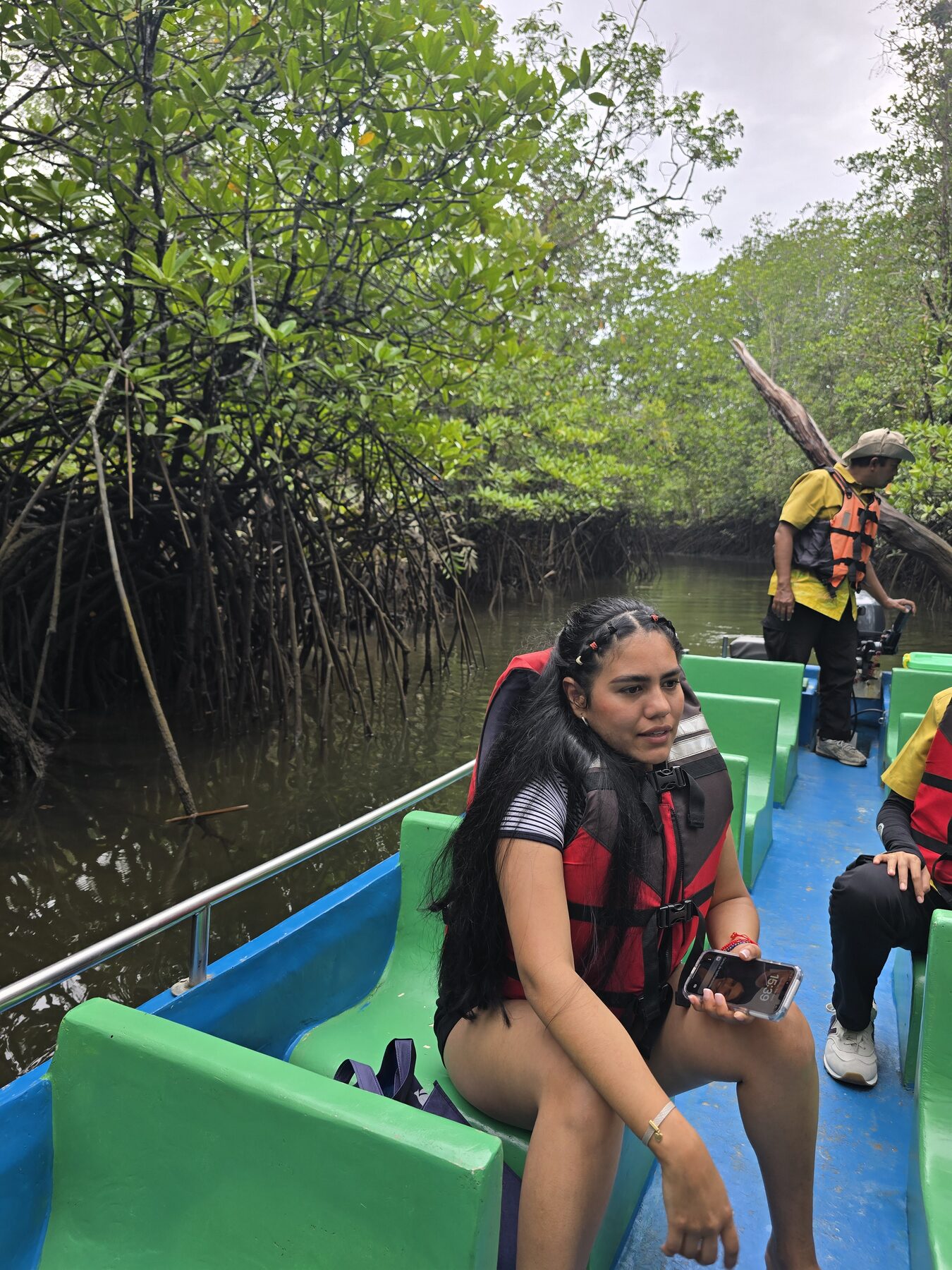 Reizigers met reddingsvesten in een kleine boot tussen de mangrovebomen