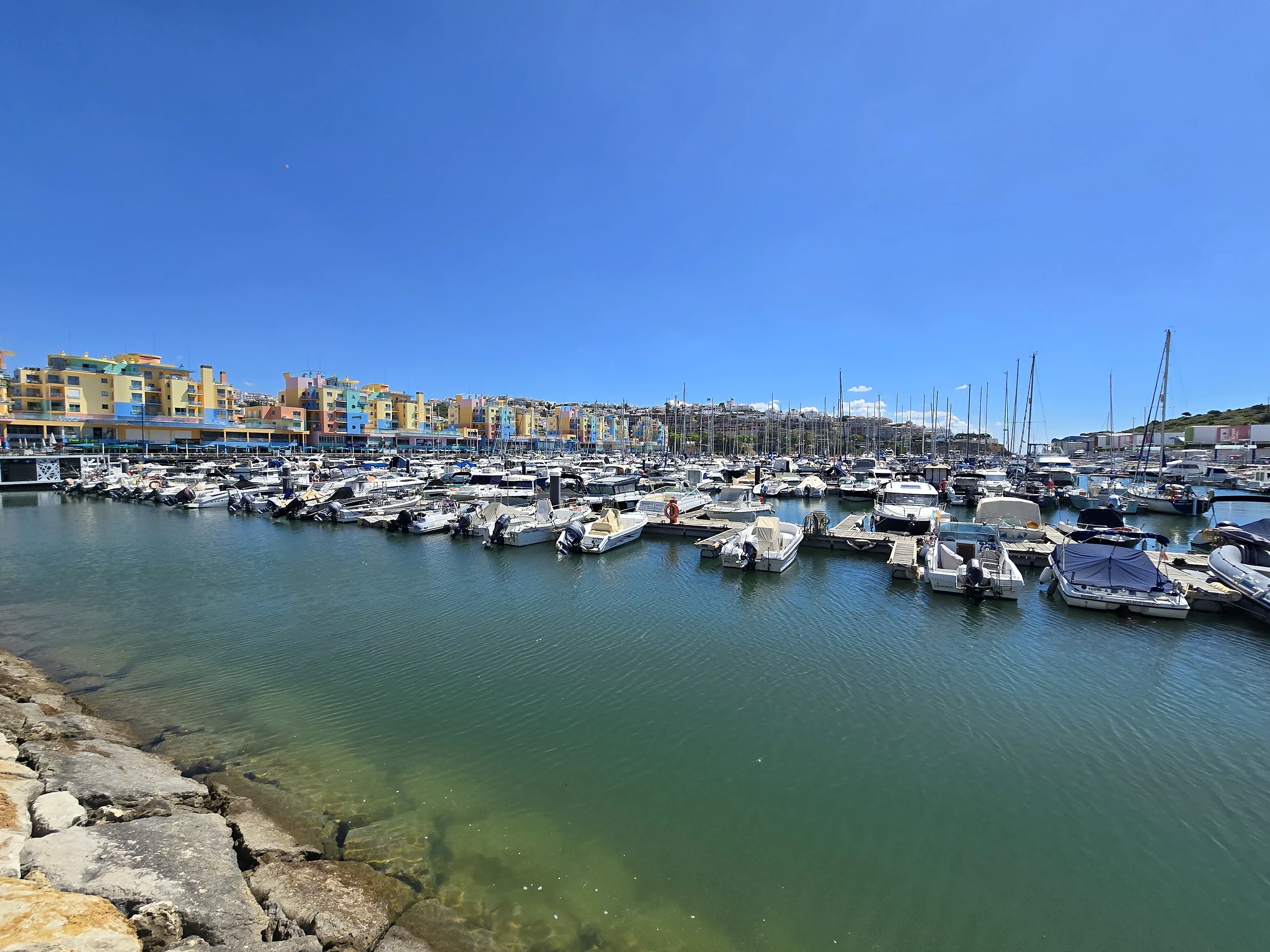 Pastelkleurige gebouwen en boten bij de jachthaven van Albufeira.