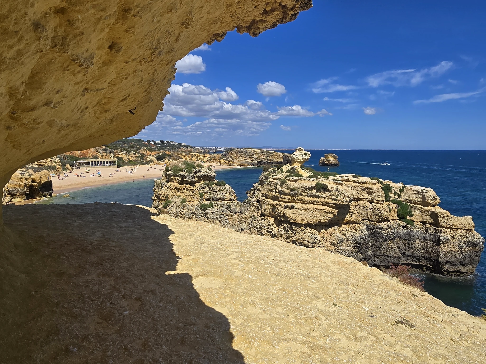 Natuurlijke rotsboog met uitzicht op rotsformaties en zee aan de Algarve.
