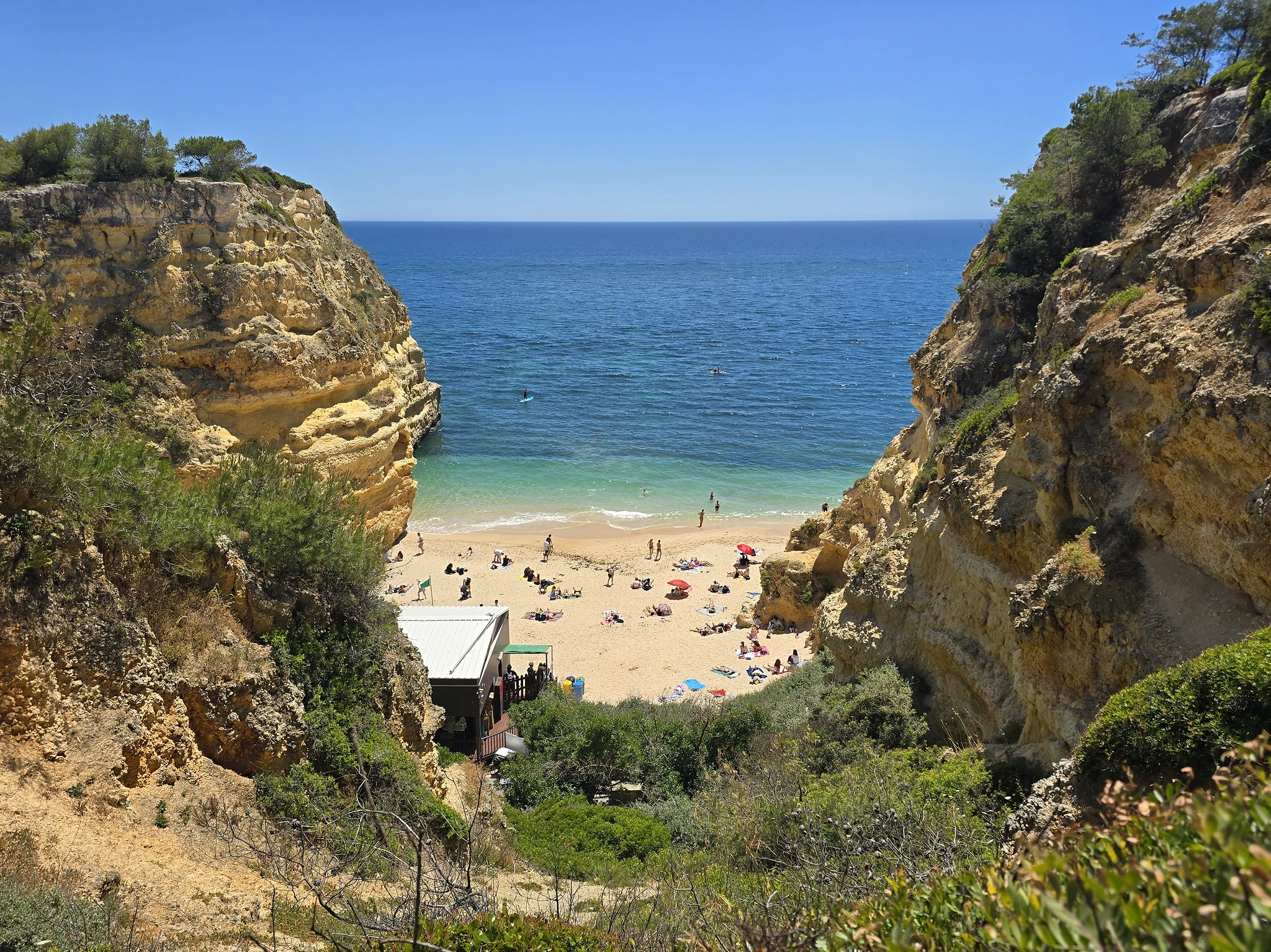 Kleine zandbaai tussen hoge rotswanden aan de Algarve.