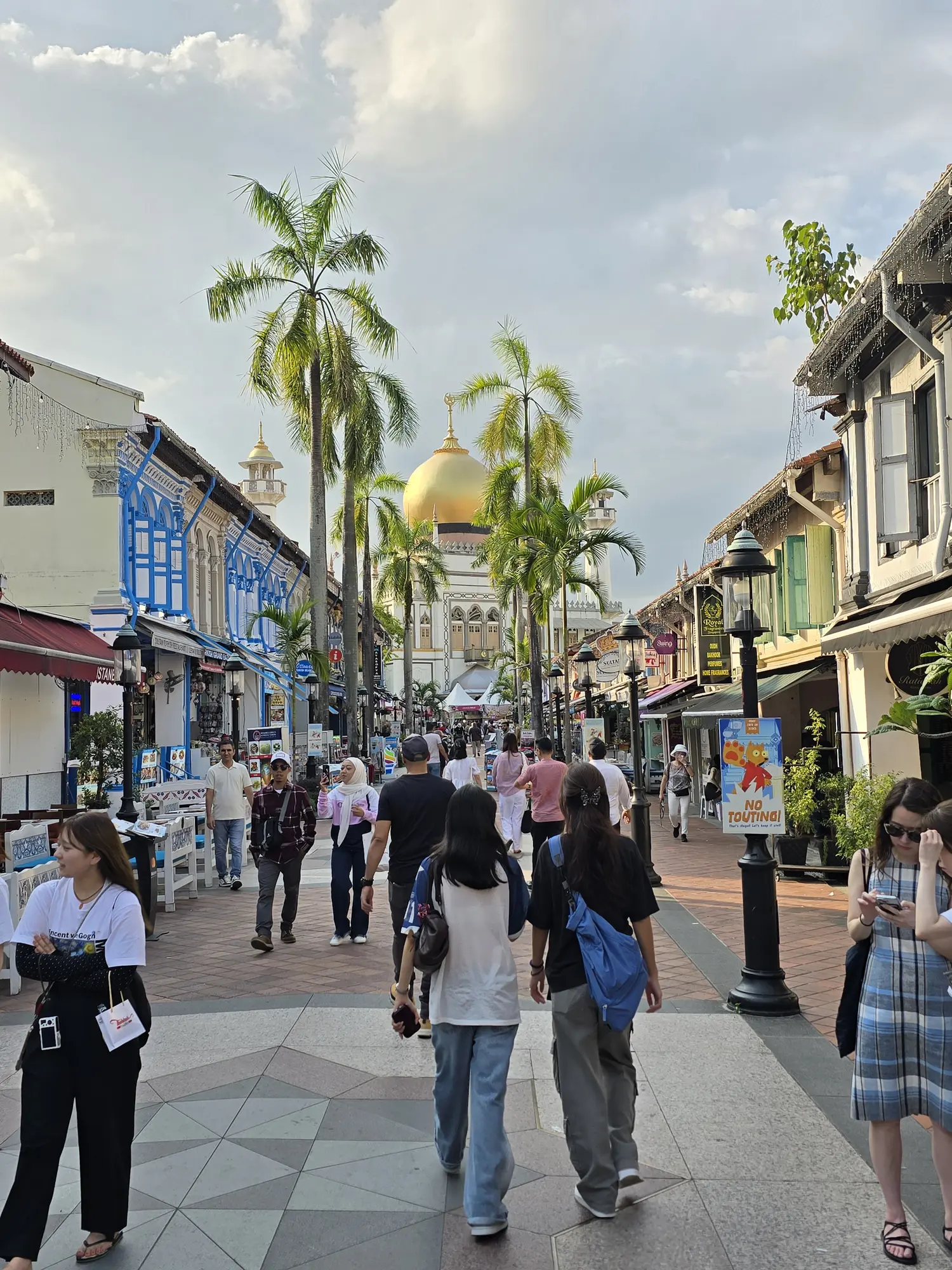 Straat in Kampong Glam met kleurrijke gevels en de gouden koepel van de Sultan Mosque